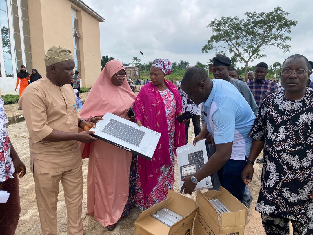 Community members examining boxed solar lights during a Foundation visit